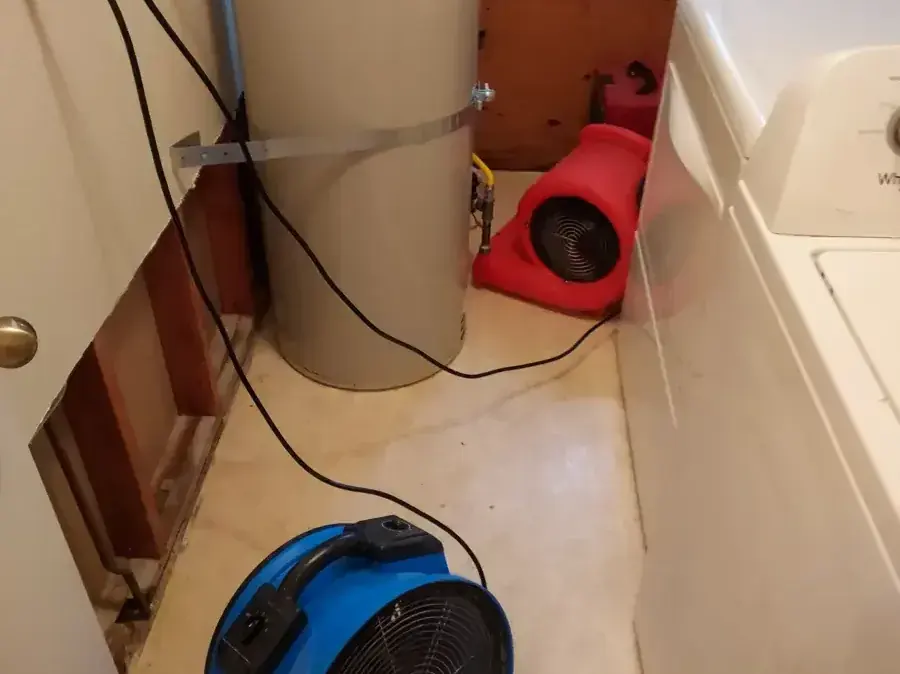 Laundry area with the wall opened behind the washer and air movers running
